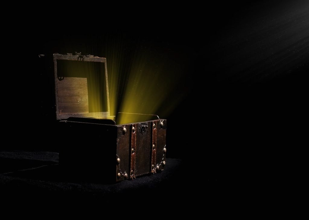 Open wooden chest emitting a mysterious glowing light in a dark room.